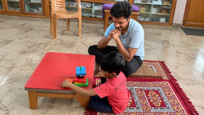 Autism Therapy Learning Activity Child participating in a structured learning activity with a therapist during an autism therapy session.