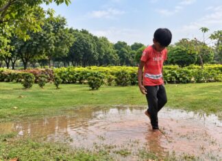 Part 4: Understanding Sensory Processing, Stimming & Behaviour in Autism Child walking barefoot through a shallow puddle while exploring outdoor sensory experiences.
