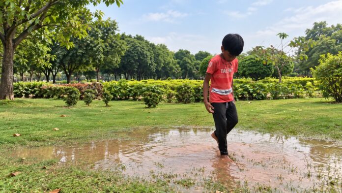 Understanding Sensory Processing Through Outdoor Play Child walking barefoot through a shallow puddle while exploring outdoor sensory experiences.