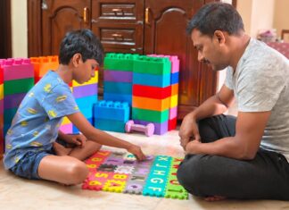 25 Early Autism Signs Parents Should Never Ignore Father sitting with his child during a learning activity at home