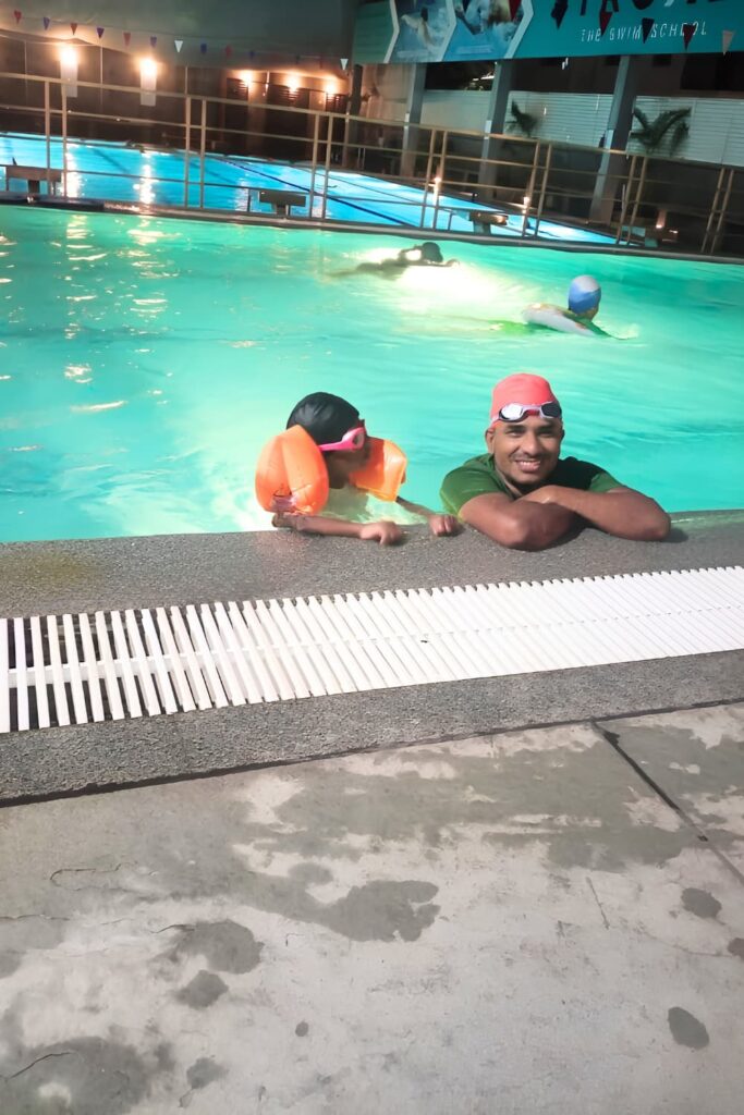 Parent and child enjoying time together in a swimming pool during a family outing.